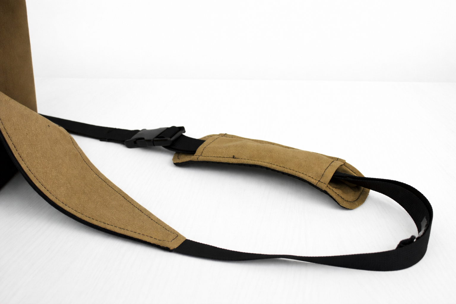 Tan strap with black buckle on a white background